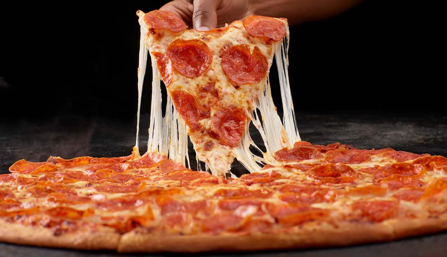 A slice being pulled from pizza